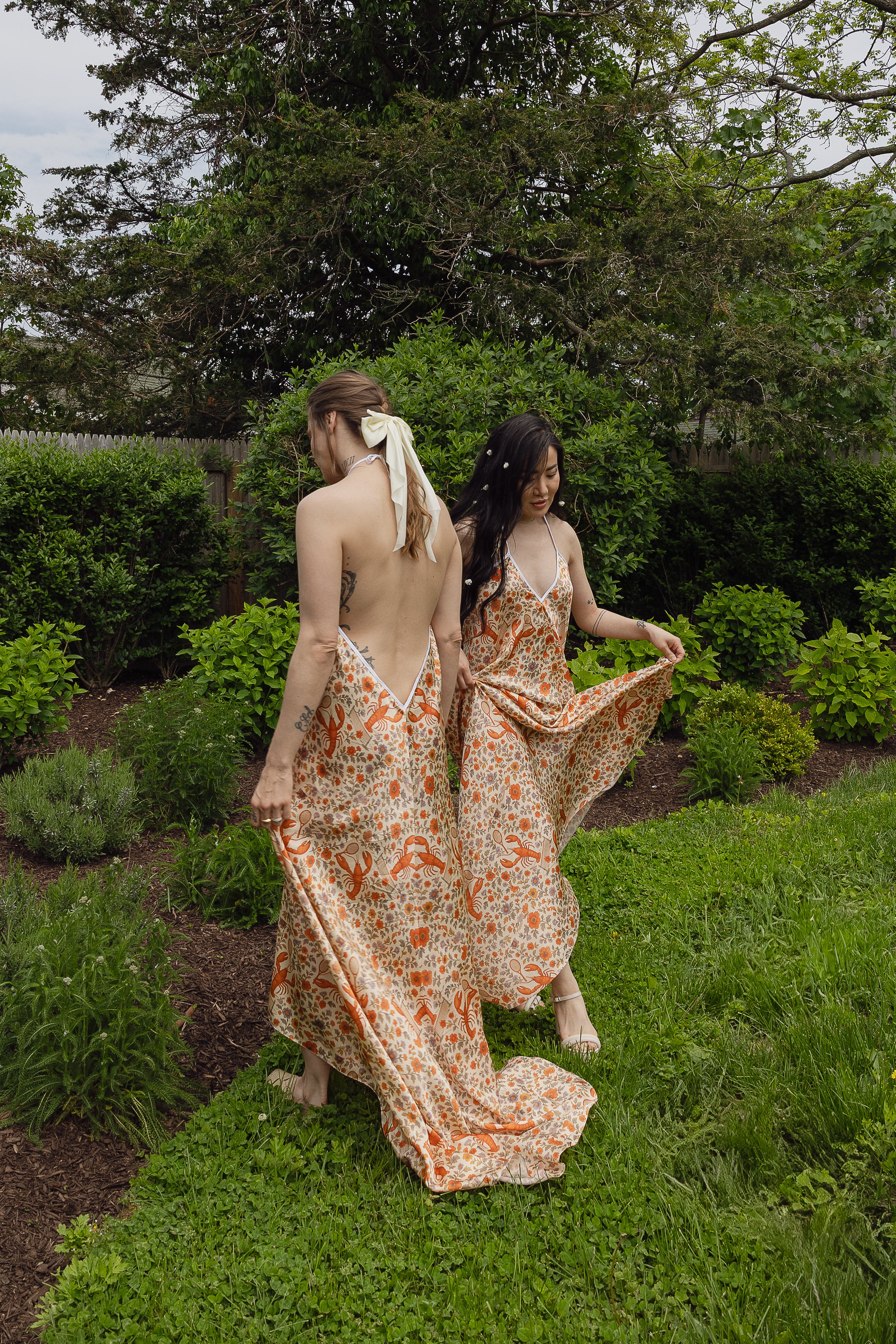 The Lobster Serve Dress in 100% silk with a tennis print, worn outdoors