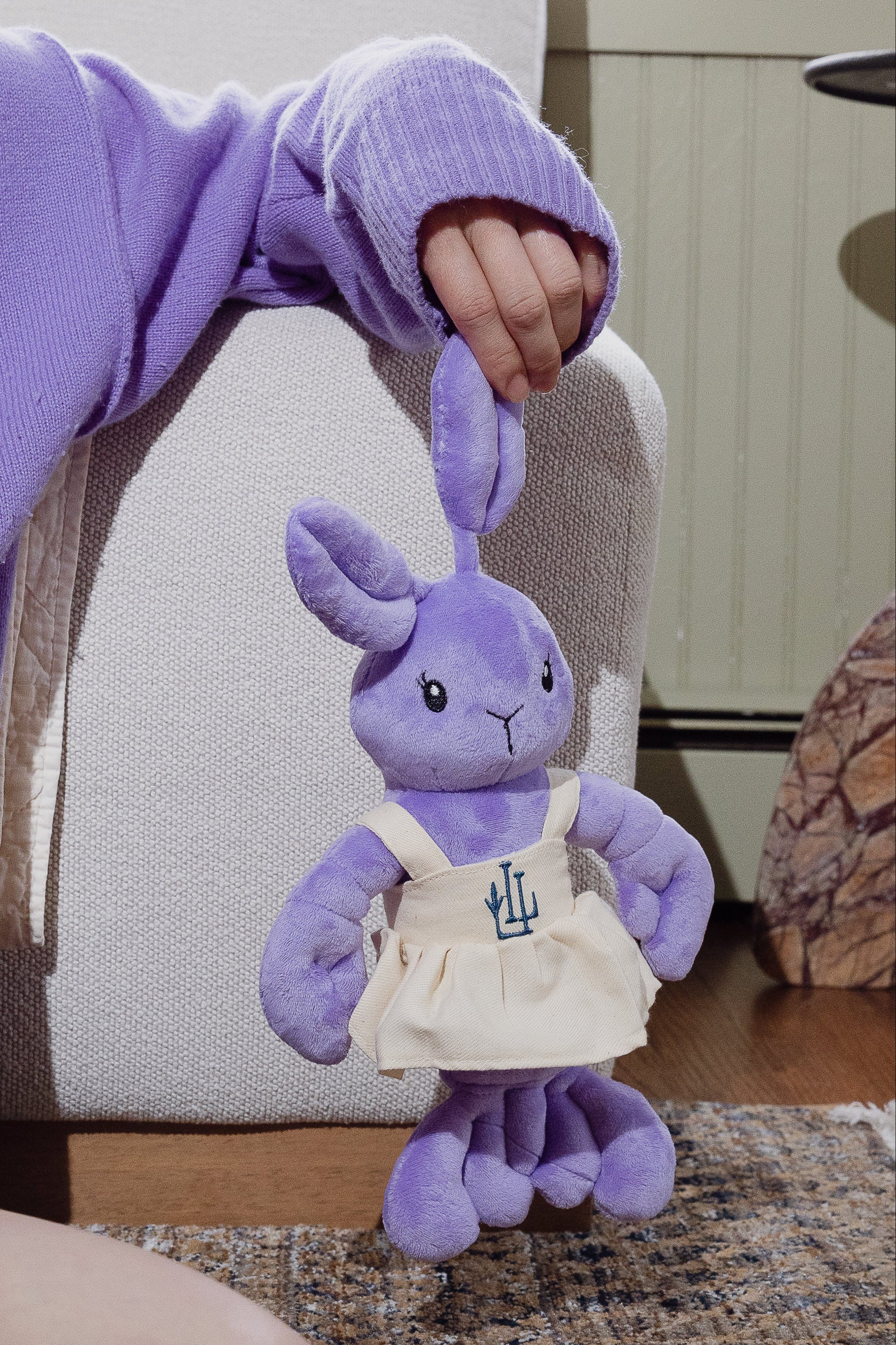 The Lavender Lobster plush toy in a linen dress with LL logo, front view