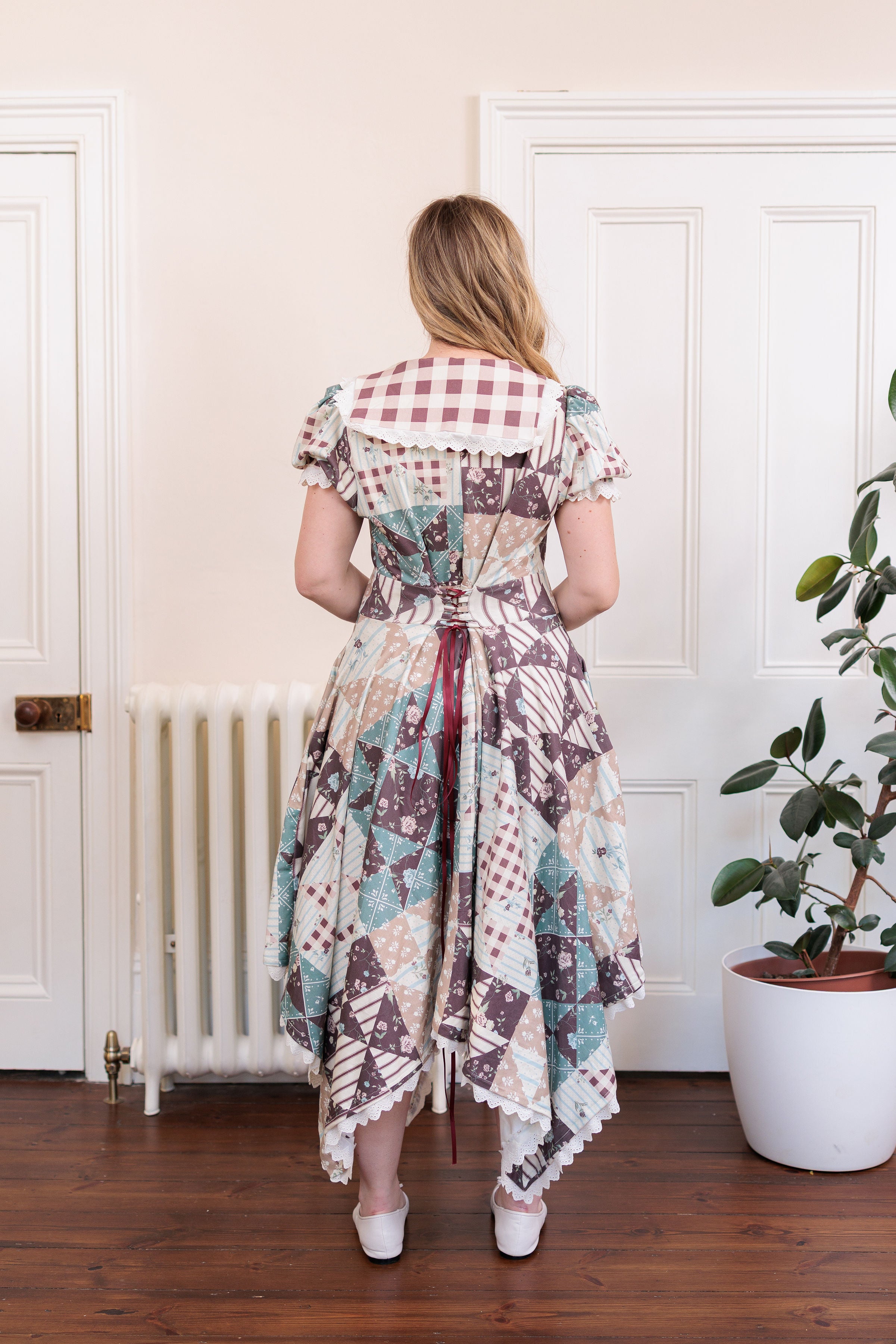 The Cottage Dress in organic cotton knit with a quilted countryside print and gingham collar, worn outdoors