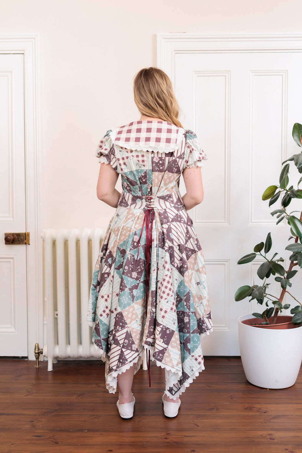 The Cottage Dress in organic cotton knit with a quilted countryside print and gingham collar, back view