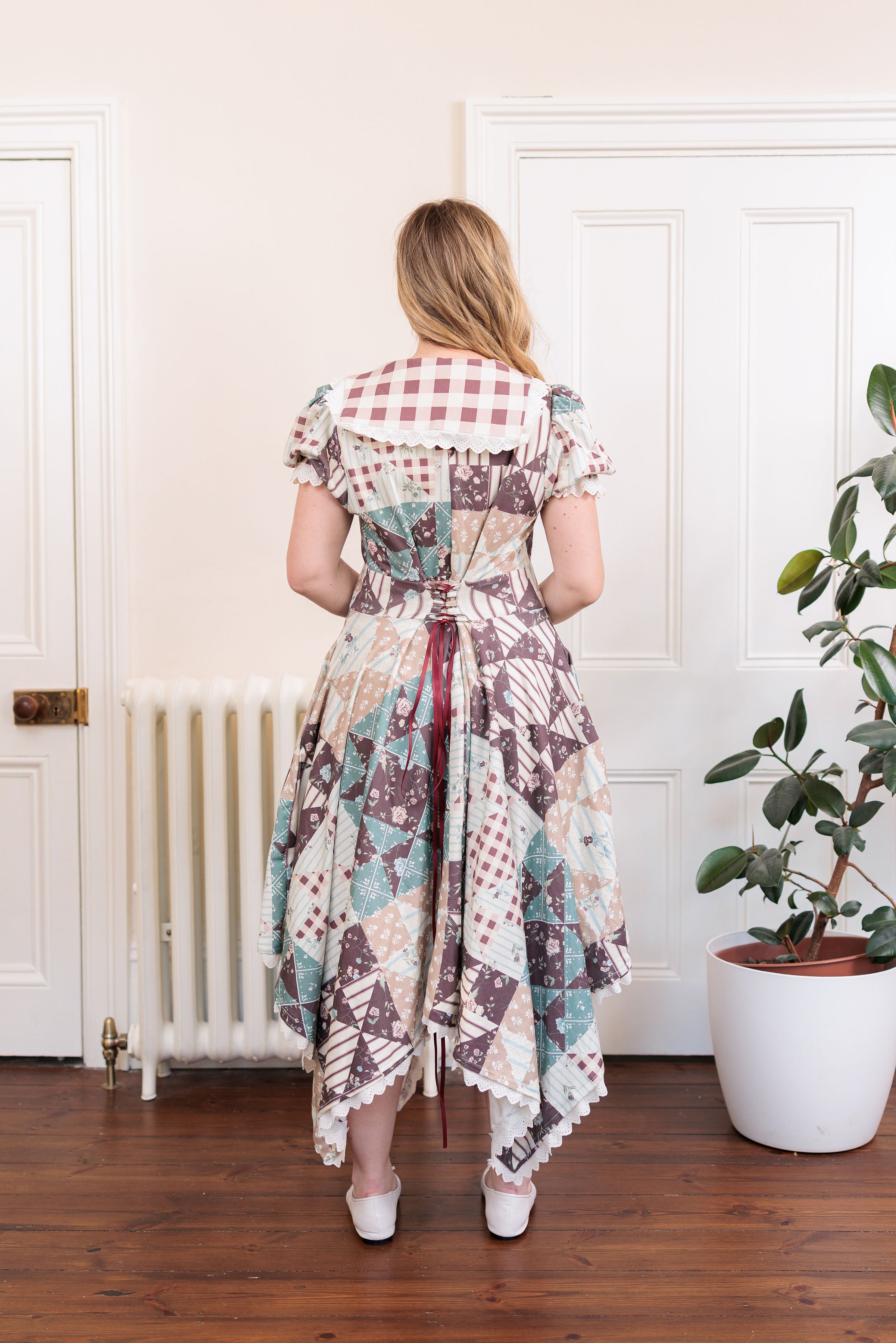 The Cottage Dress in organic cotton knit with a quilted countryside print and gingham collar, back view